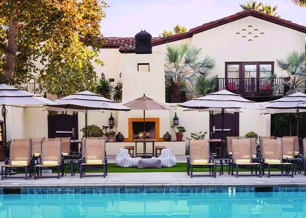 Poolside at the Estancia La Jolla Hotel & Spa with umbrellas and chairs on a sunny day